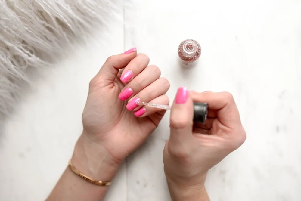 Manicura rosa sobre superficie de mármol